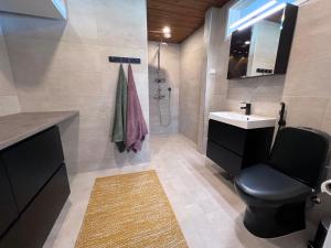 a bathroom with a toilet and a sink and a shower at Villa Resort Apartments by Hiekka Booking in Kalajoki