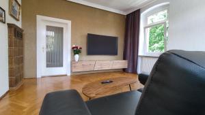 sala de estar con TV de pantalla plana y mesa en Ferienwohnung Eppendorf, en Eppendorf