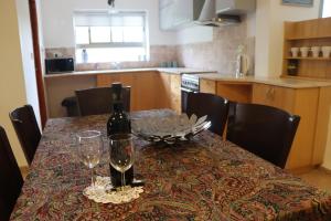 uma mesa com uma garrafa de vinho e copos em צימר ספא em Kefar Weradim