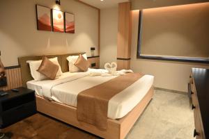 a bedroom with a large bed in a room at JVL By Nexottel in Rajkot