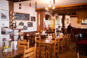 a man standing in a restaurant with tables and chairs at Slieve League Lodge in Carrick