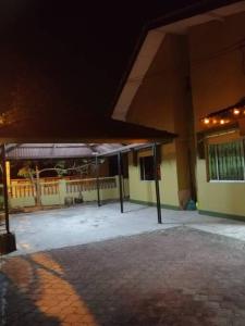 a building with a pavilion in front of it at night at Hajjah Homestay Tg Agas Muar in Muar