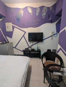 1 dormitorio con paredes de color púrpura y blanco y 1 cama en 一中宿屋 en Taichung
