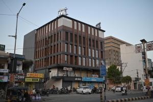 un edificio su una strada trafficata della città con auto e moto di JVL By Nexottel a Rajkot