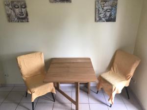 a wooden table and two chairs in a room at Chambre du merle in Illats