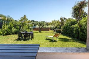 a yard with a table and chairs in the grass at N084 - Numana, villa quadrilocale con meraviglioso giardino in Numana