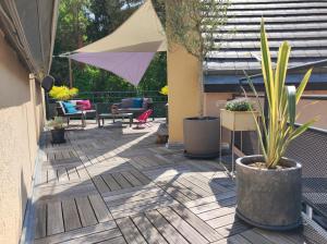 a patio with potted plants and an umbrella at "Le Rooftop de la fontaine" dans cadre verdoyant in Luisant