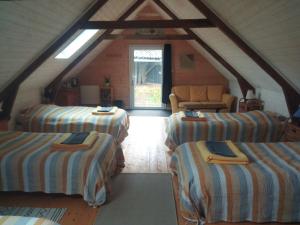 a attic room with three beds and a couch at Le Jardin Enchanteur, chaleureuse maison d'hôtes éco-responsable, calme et accueillante in Lopérec +21 photos