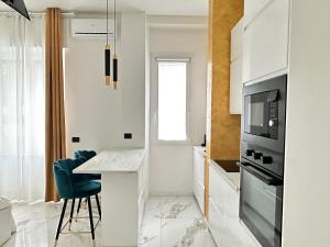 a white kitchen with a table and a microwave at Maison Chanel in Milan