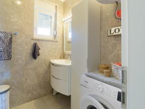 a bathroom with a washing machine and a sink at Apartment Harmony in Umag