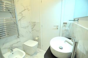 bagno bianco con lavandino e servizi igienici di San Cosimato 40 guesthouse a Roma