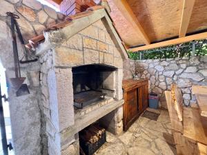 an outdoor pizza oven with a stone wall at Apartman Milly in Grižane