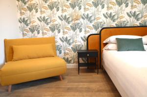 una camera con un letto e una sedia con carta da parati floreale di San Cosimato 40 guesthouse a Roma