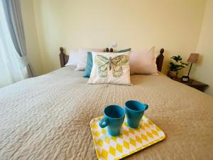 a bed with two blue cups on a tray at Apartment in Bansko, very close to the Gondola in Bansko