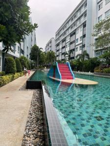 uma piscina com escorrega no meio de um edifício em The Trust Condo by the Sea em Hua Hin