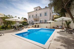 a villa with a swimming pool in front of a house at Villa Cassia in Mali Lošinj