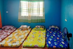 three beds in a room with a window at Sunset Beach and Family Resort Gonzaga Cagayan in Bawa