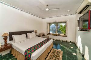 a bedroom with a large bed and a television at YAAN Udaipur in Udaipur