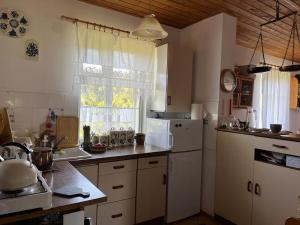 a kitchen with a white refrigerator and a sink at Domek Radość in Cieksyn
