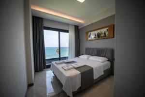 Schlafzimmer mit einem Bett und Meerblick in der Unterkunft Artan Suites Tatil Evleri in Güzelçamlı