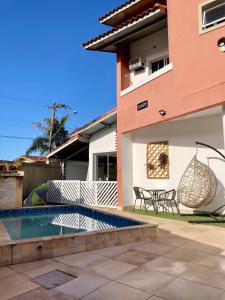 a villa with a swimming pool and a house at Casa lazer completo 200m da praia in Praia Grande