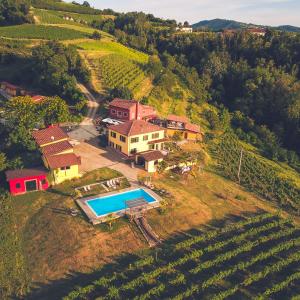 an aerial view of a house on a hill with a swimming pool at Tenuta MonteOliveto - Romantic Cottage - Agriturismo nelle Langhe in Vesime +27 photos