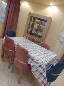 a dining room table with chairs and a checkered table cloth at فيلا لوزان الريف الاوروبي in ‘Ezbet Sharikât Wardan