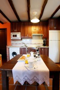 a kitchen with a table with a white table cloth at Apartamento Puerta del Sol de 1 habitación in Candelario