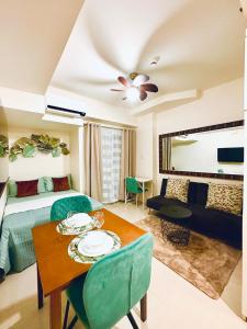 um quarto com uma cama e uma mesa com pratos em Lengs Place 2 - Studio Unit with Balcony at Inspiria Condo em Davao