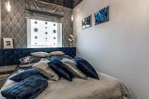 een bed met kussens in een slaapkamer bij #MazuryGlamour in Giżycko