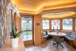 ein Esszimmer mit einem Tisch, Stühlen und Fenstern in der Unterkunft Romantik Ferienwohnungen in Pertisau