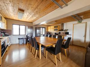 a kitchen and dining room with a wooden table and chairs at Aurora Mountain Cabins & Hostel in Lannavaara