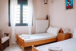 ein kleines Zimmer mit 2 Betten und einem Fenster in der Unterkunft Pagiantes in Agios Nikolaos