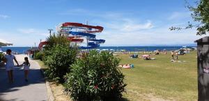 a group of people at a beach with a roller coaster at Simonov zaliv Apartment LAGUNA 17 in Izola