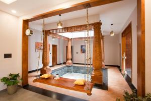 an indoor pool with a swing in a house at Regal Retreat by VEO - Part of StayVista in Wayanad