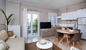 a living room with a couch and a table and a kitchen at Sti Chora Apartments in Lefkada