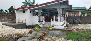 a small white house with a porch and a deck at ALTHEA BIRDS NEST INN in Moalboal