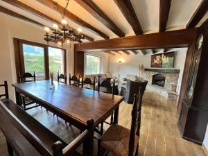 a dining room with a table and a fireplace at Cal Poldo in Marganell