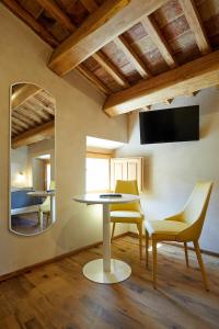 una sala da pranzo con tavolo, sedie e specchio di Agriturismo Montecolombo by Il Ritorno a Massignano