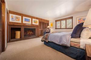 1 dormitorio con 1 cama grande y chimenea en Bray House - Ski-in Ski-out family home, en Teton Village