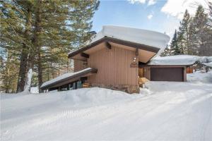 提頓村的住宿－Bray House - Ski-in Ski-out family home，树林里屋顶上积雪的小屋