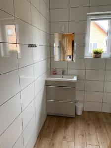 uma casa de banho com um lavatório e um espelho em Zielona Dolina Sarbinowo em Sarbinowo