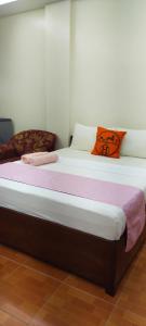 ein Bett in einem Zimmer mit einer rosa Decke darauf in der Unterkunft ALTHEA BIRDS NEST INN in Moalboal