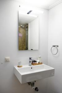 a bathroom with a white sink and a mirror at Sti Chora Apartments in Lefkada Town