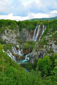 a waterfall in the middle of a mountain with a river at House Magdic Plitvice in Grabovac