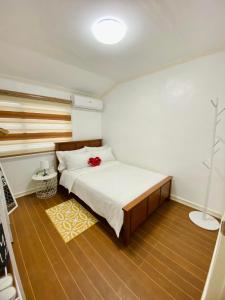 - une chambre avec un lit orné d'une fleur rouge dans l'établissement Gillera Staycation in Lipa, à Lipa