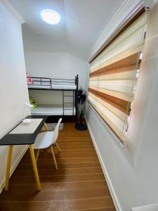 Gillera Staycation in Lipa في ليبا: غرفة مع سرير بطابقين ومكتب
