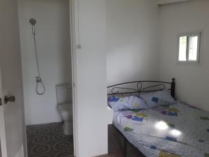a bedroom with a bed and a bathroom with a toilet at El Nido Bayview in El Nido