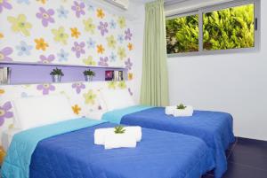 two blue beds in a room with flowers on the wall at Sivota Senses - Villa Loukas in Syvota