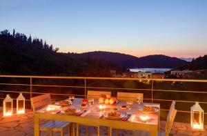 una mesa con comida y luces en el balcón en Sivota Senses - Villa Loukas en Syvota